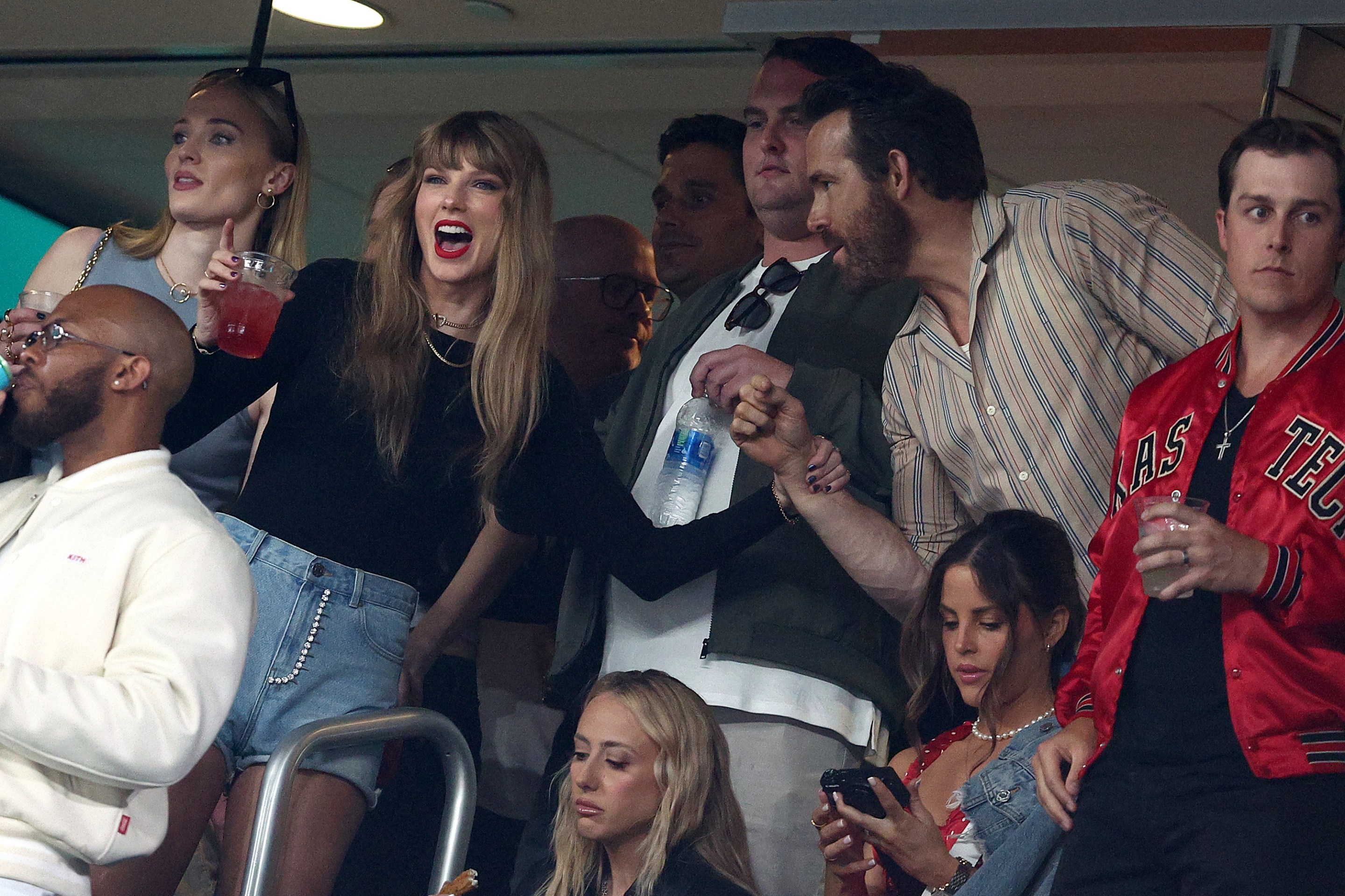 Singer Taylor Swift and Actor Ryan Reynolds talk prior to the game between the Kansas City Chiefs and the New York Jets at MetLife Stadium on October 01, 2023 in East Rutherford, New Jersey.