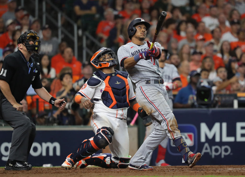 Jorge Polanco of the Minnesota Twins at home hits a home run as the catcher and umpire observe during the seventh inning against the Houston Astros during Game One of the Division Series at Minute Maid Park on October 07, 2023 in Houston, Texas.