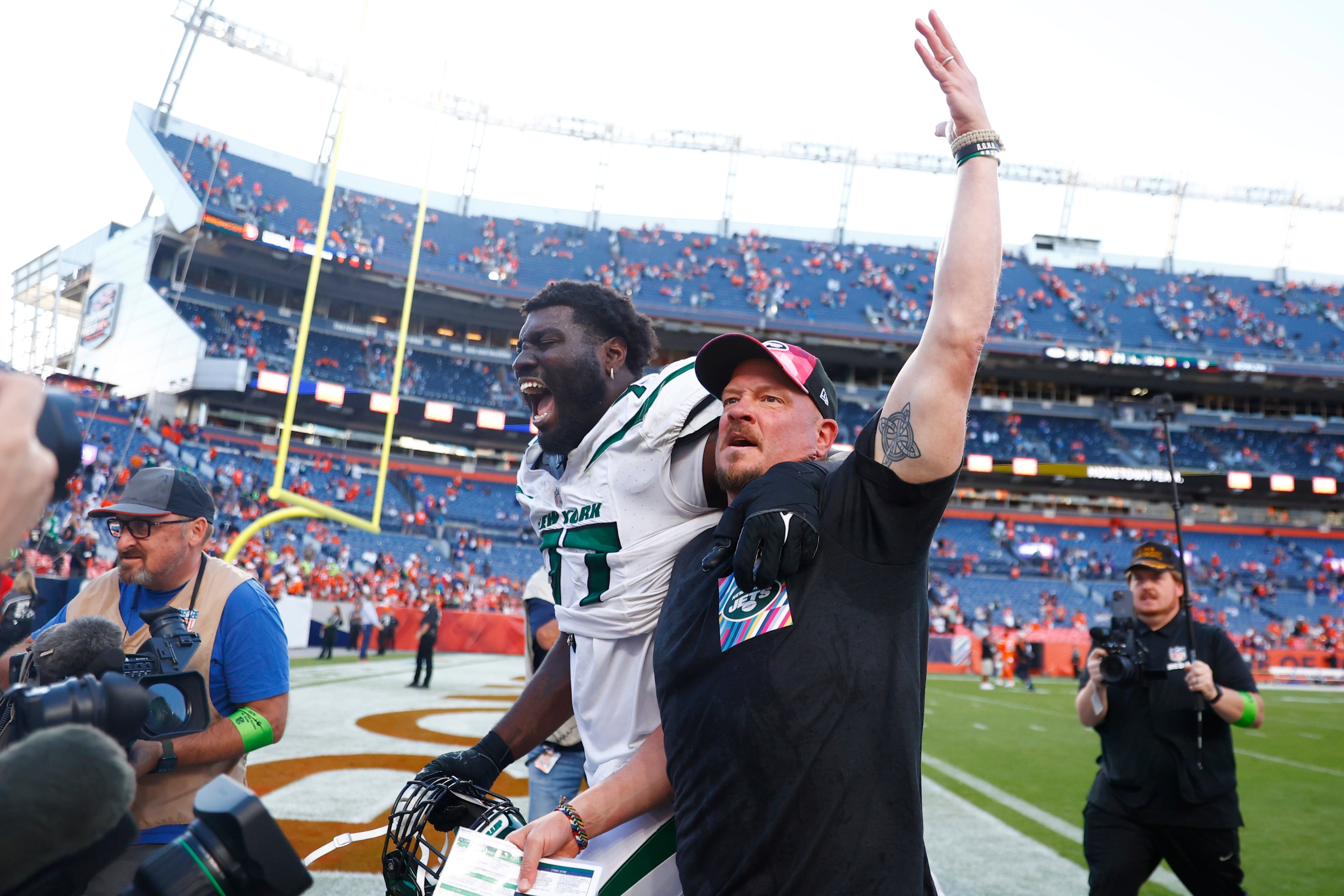 Mekhi Becton #77 and offensive coordinator Nathaniel Hackett of the New York Jets celebrate after beating the Denver Broncos 31-21 at Empower Field At Mile High on October 08, 2023 in Denver, Colorado.
