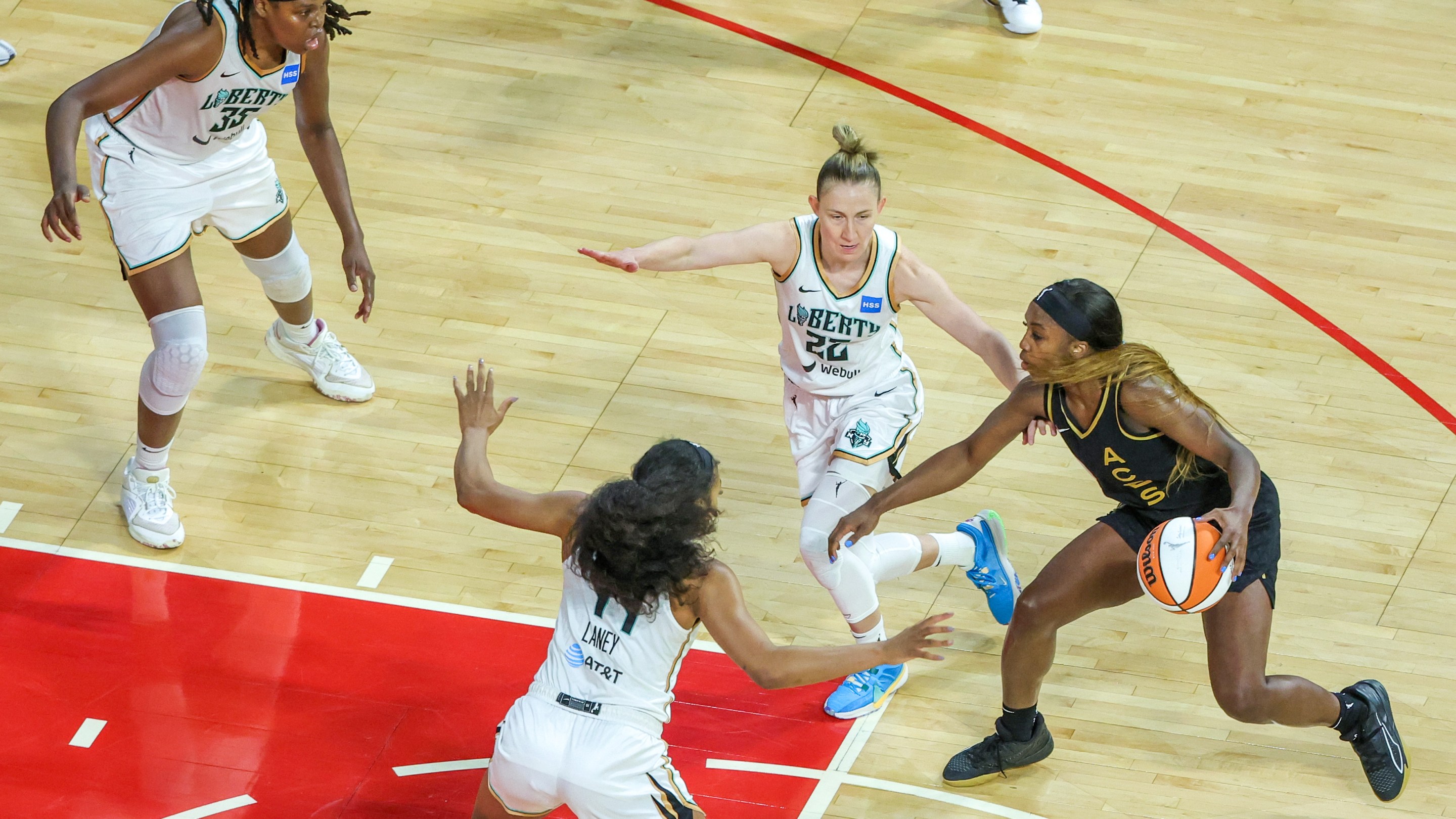 Jackie Young #0 of the Las Vegas Aces handles the ball under pressure from Jonquel Jones #35, Betnijah Laney #44 and Courtney Vandersloot #22 of the New York Liberty in the fourth quarter of Game One of the 2023 WNBA Playoffs finals at Michelob ULTRA Arena on October 08, 2023 in Las Vegas, Nevada. The Aces defeated the Liberty 99-82.