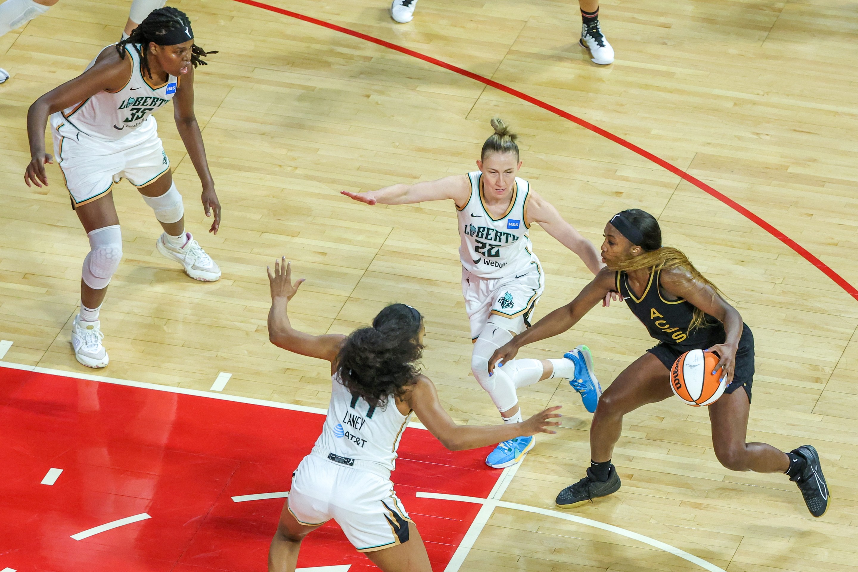 Jackie Young #0 of the Las Vegas Aces handles the ball under pressure from Jonquel Jones #35, Betnijah Laney #44 and Courtney Vandersloot #22 of the New York Liberty in the fourth quarter of Game One of the 2023 WNBA Playoffs finals at Michelob ULTRA Arena on October 08, 2023 in Las Vegas, Nevada. The Aces defeated the Liberty 99-82.
