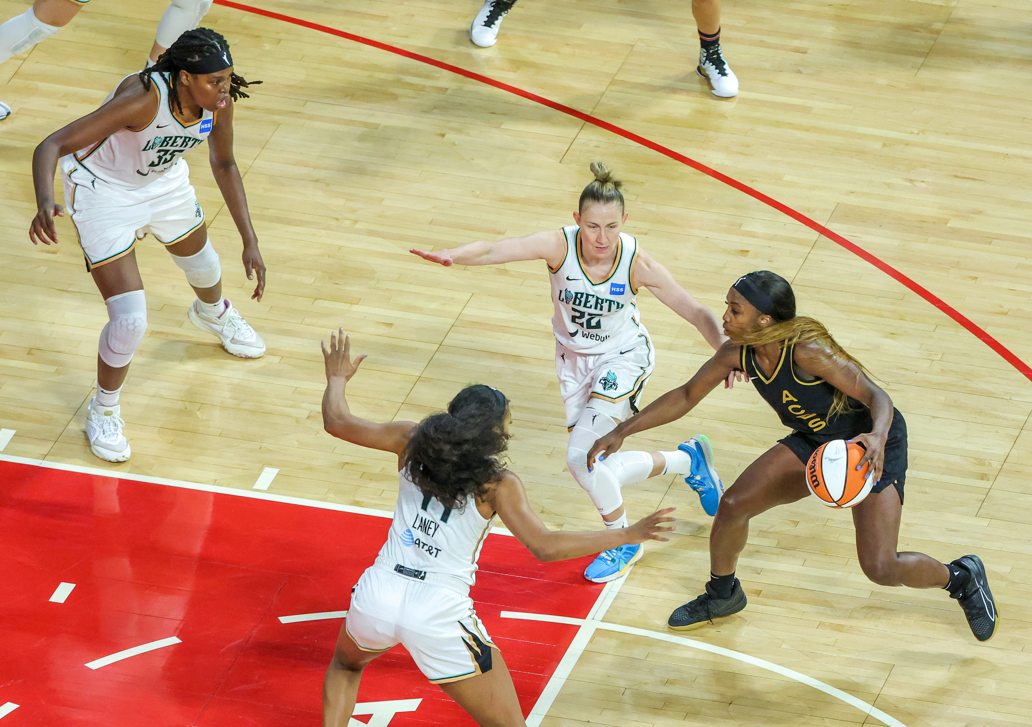 Jackie Young #0 of the Las Vegas Aces handles the ball under pressure from Jonquel Jones #35, Betnijah Laney #44 and Courtney Vandersloot #22 of the New York Liberty in the fourth quarter of Game One of the 2023 WNBA Playoffs finals at Michelob ULTRA Arena on October 08, 2023 in Las Vegas, Nevada. The Aces defeated the Liberty 99-82.