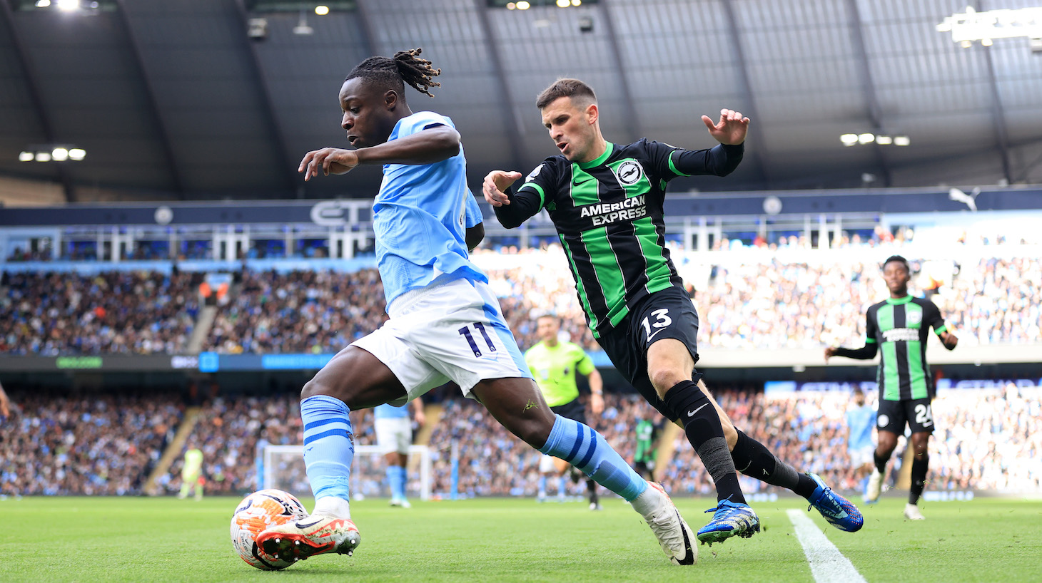 Jeremy Doku of Manchester City battles with Pascal Gross of Brighton & Hove Albion during the Premier League match between Manchester City and Brighton & Hove Albion at Etihad Stadium on October 21, 2023 in Manchester, England.