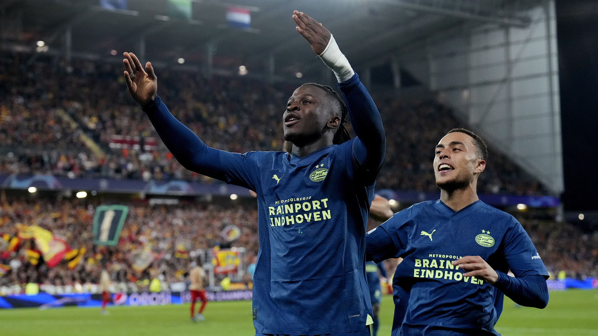 Johan Bakayoko of PSV celebrates 0-1 with Sergino Dest of PSV during the UEFA Champions League match between RC Lens v PSV at the Stade Bollaert Delelis on October 24, 2023 in Lens France