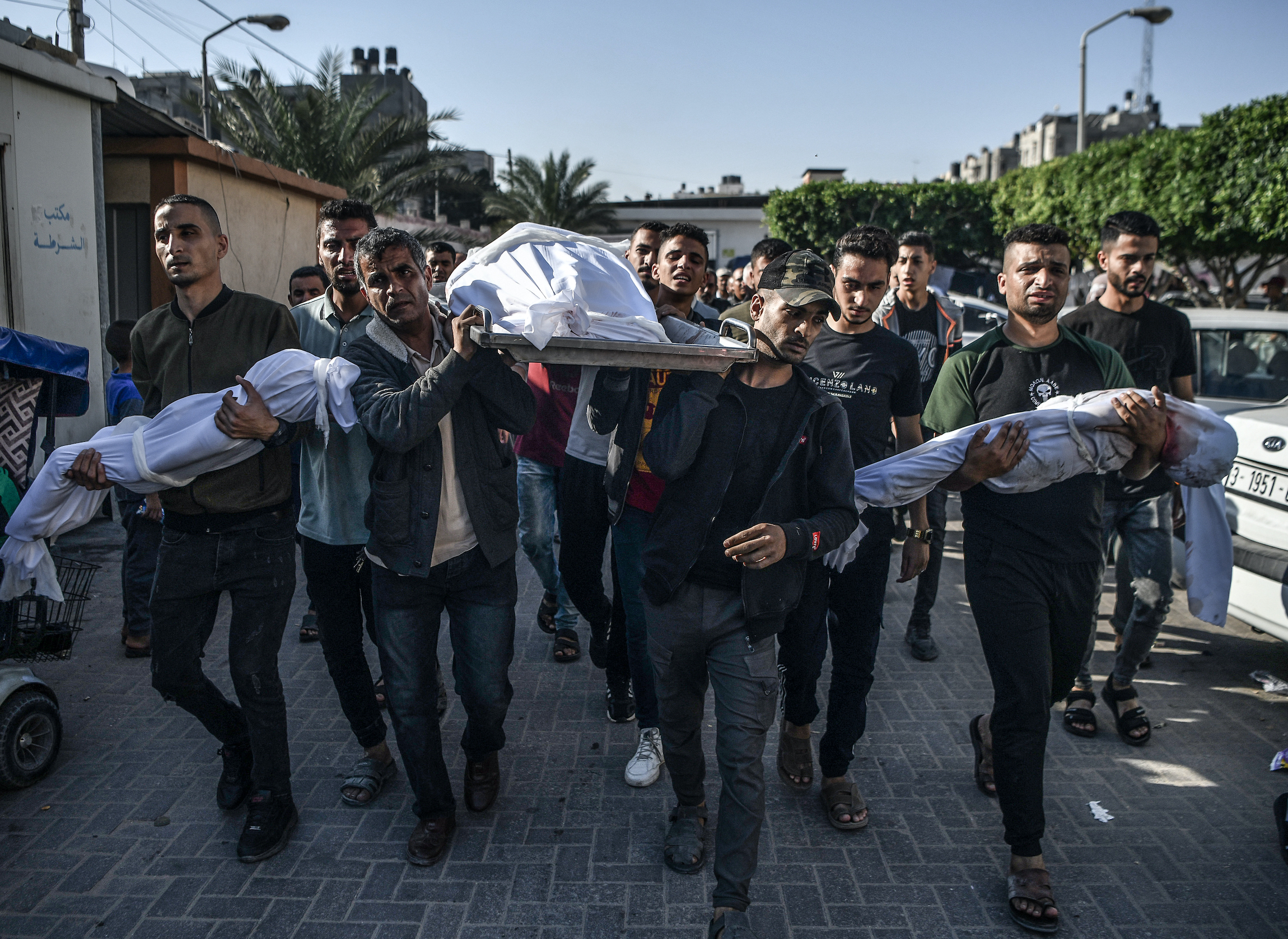 Palestinians in Gaza carry bodies through the street