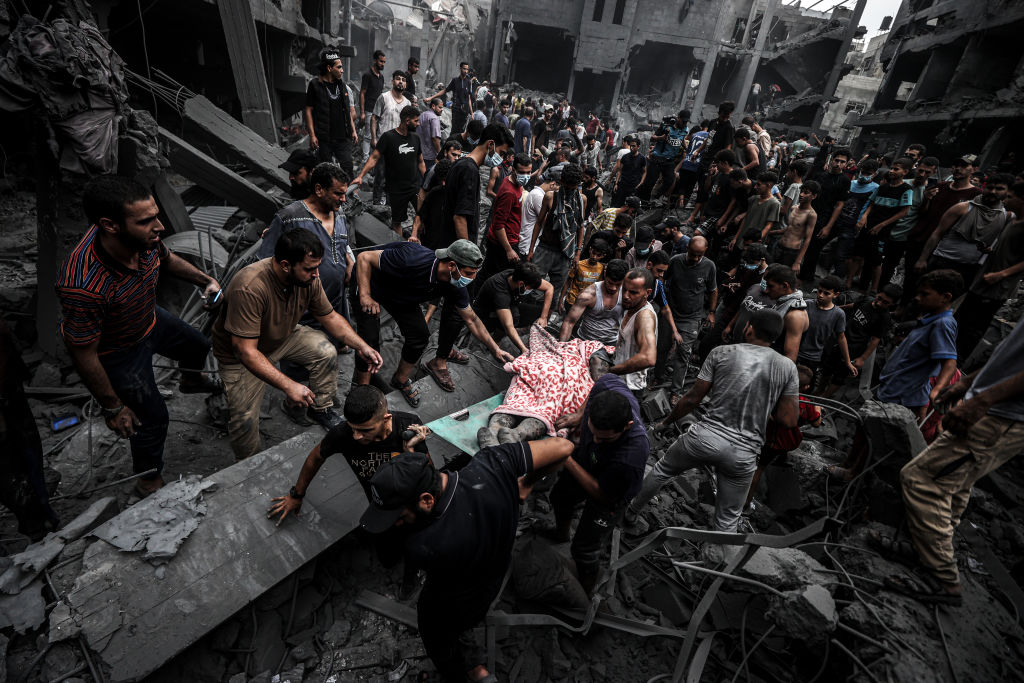 People carry injured and dead Palestinians from the rubbles of buildings as civil defense teams and civilians conduct search and rescue operations after Israeli attacks on Al-Shati refugee camp of Gaza City, Gaza on October 27, 2023 as Israeli attacks continue on the 21st day on Gaza