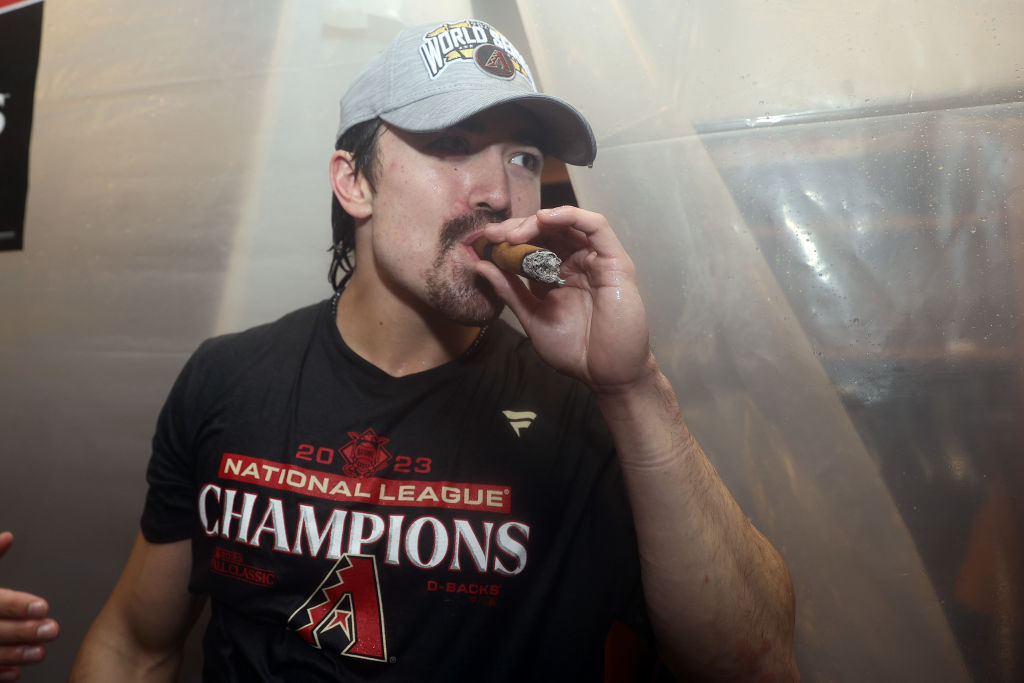 Corbin Carroll celebrates by smoking a cigar in the clubhouse