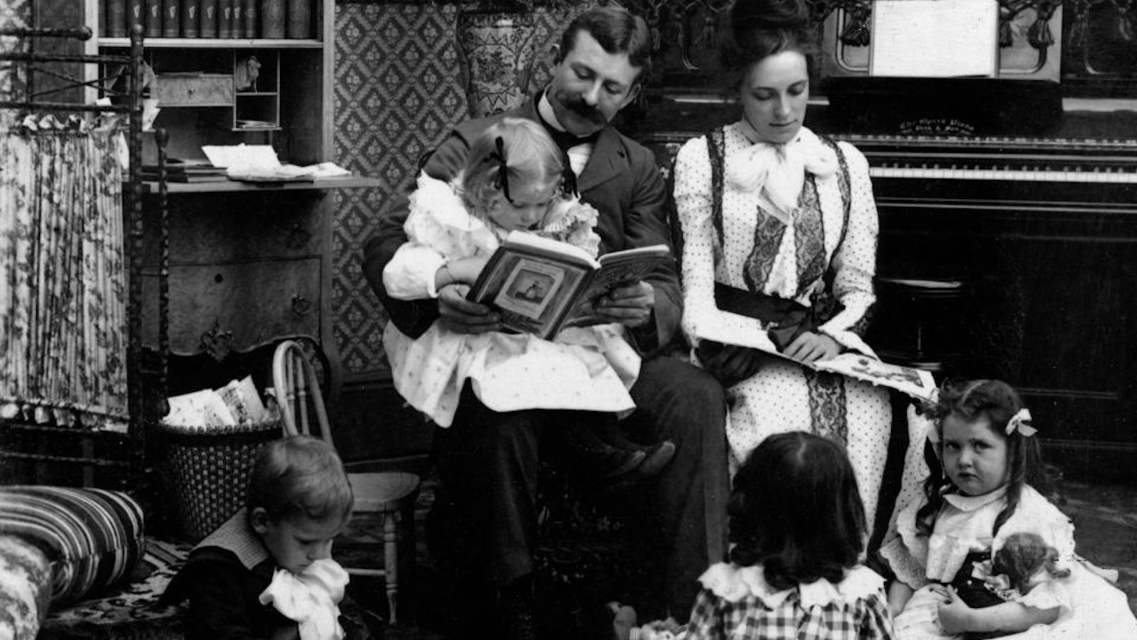 An old-timey family reading books.