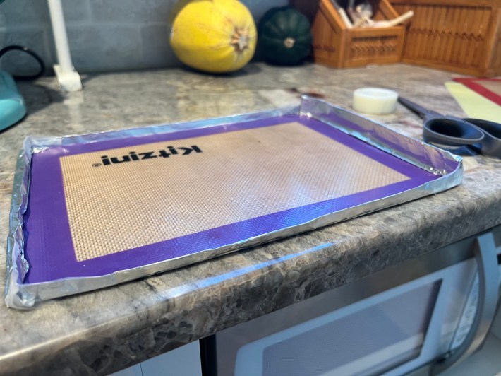 A thin tray made out of tin foil and a silicone mat.