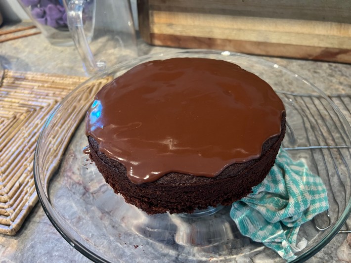 Liquid ganache pools on top of a warm sponge as Chris's bake teeters on the edge of catastrophe.