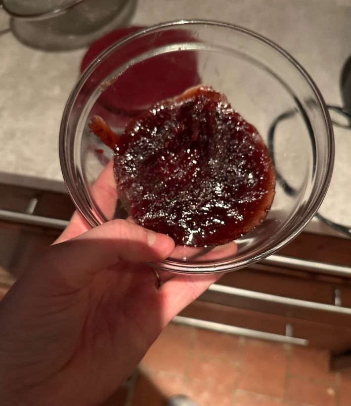 very hard jam stuck at the bottom of a glass bowl