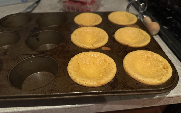 Six tiny cheesecakes in a muffin tin