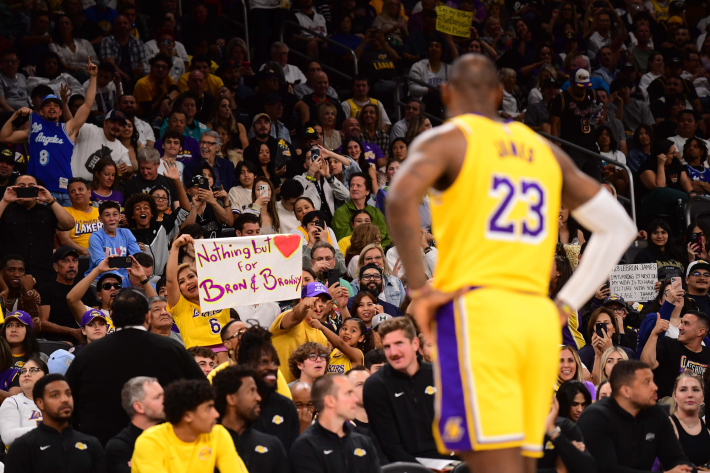 LeBron James of the Los Angeles Lakers, out of focus in the foreground of a shot of the crowd at a Lakers preseason game.