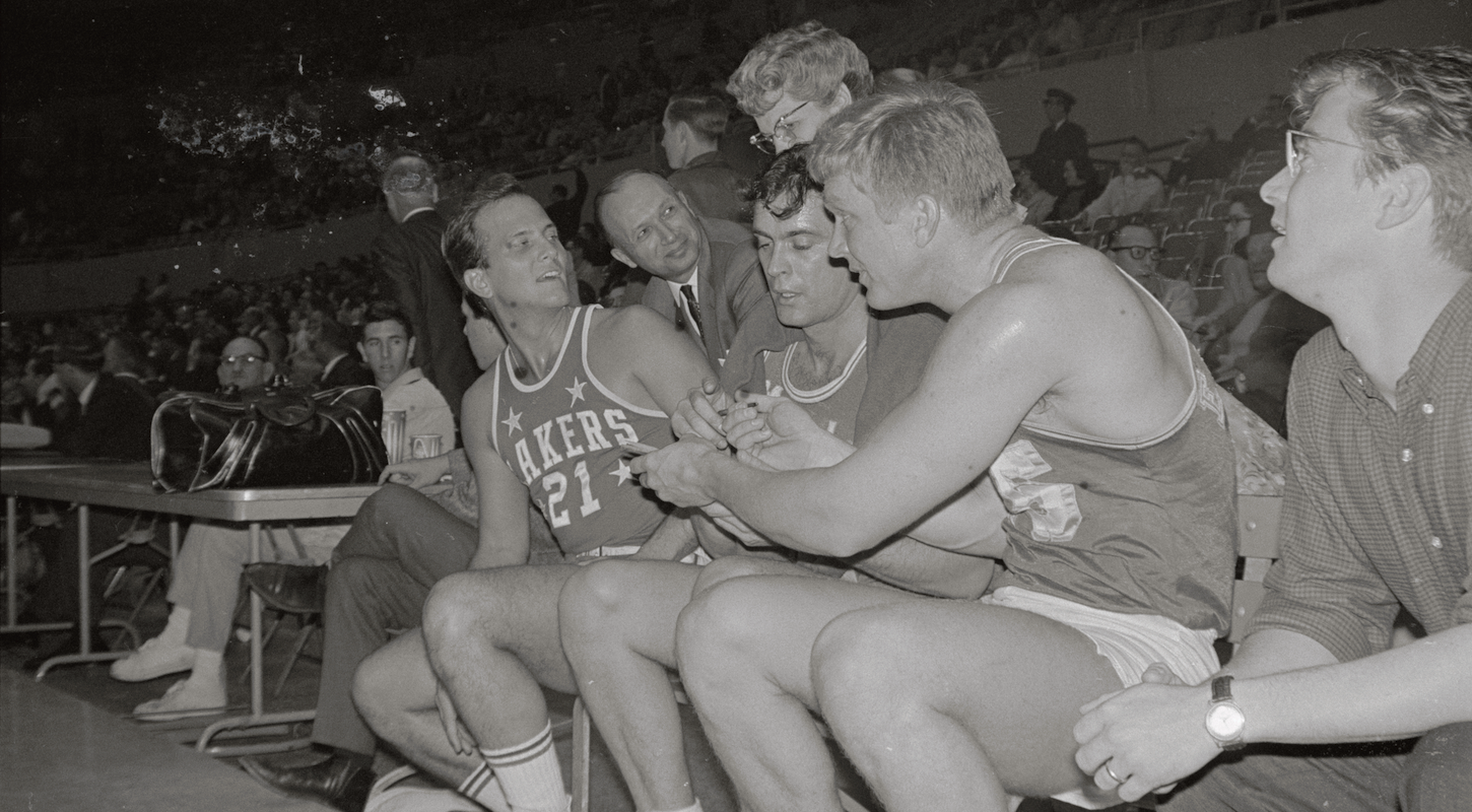 A bunch of old-timey celebrities, including Pat Boone, sign autographs in Lakers uniforms during a charity game in Ye Olden Tymes.