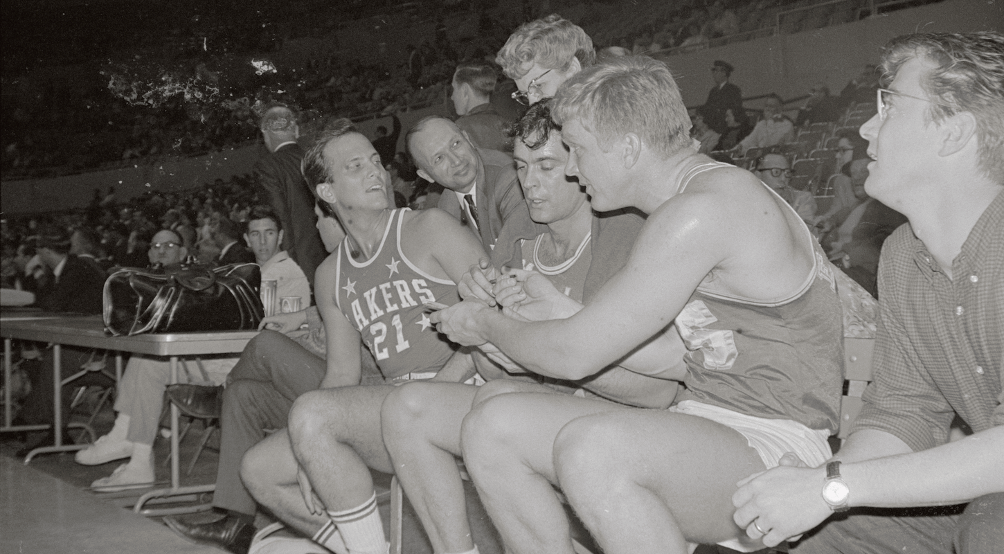 A bunch of old-timey celebrities, including Pat Boone, sign autographs in Lakers uniforms during a charity game in Ye Olden Tymes.