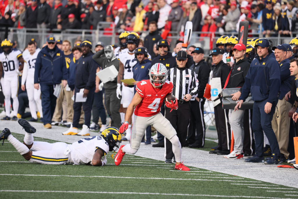 College Football: Ohio State Julian Fleming (4) in action, runs with the football vs Michigan at Ohio Stadium. Football analyst Connor Stalions and head coach Jim Harbaugh present in the background. Columbus, Ohio, November 26, 2022. In this photo edit, Stalion has been made black and white.