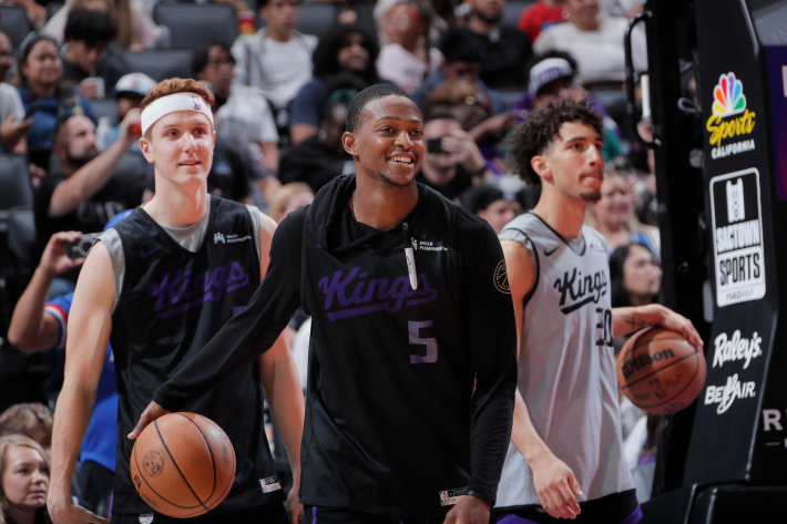 Kevin Huerter, De'Aaron Fox, and Colby Jones of the Sacramento Kings, during warmups before a preseason game.