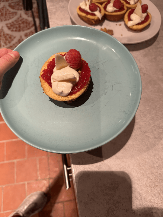 One tiny cheesecake on a blue plate.