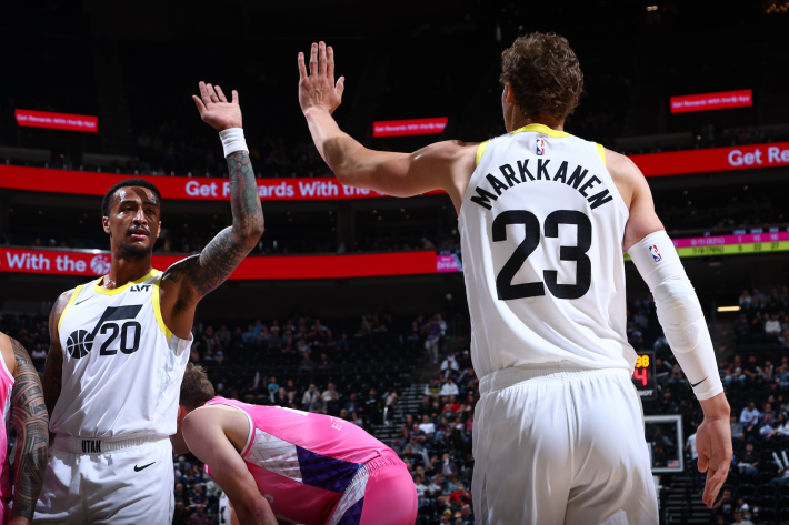 Lauri Markkanen and John Collins of the Utah Jazz high-five during a preseason game.