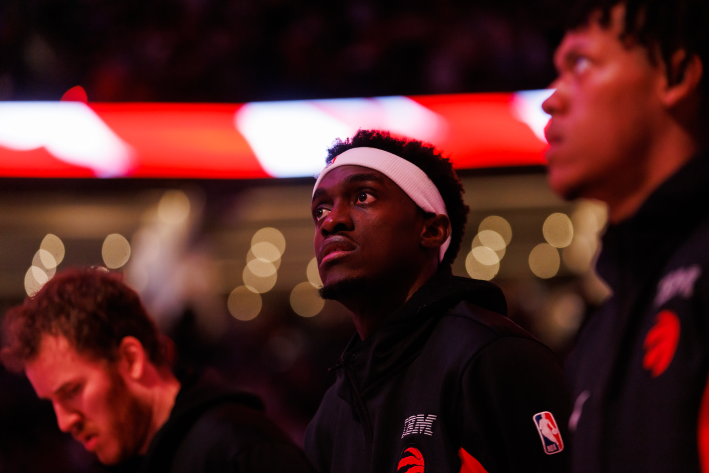 Pascal Siakam of the Toronto Raptors, illuminated by red light during the national anthem before a preseason game.