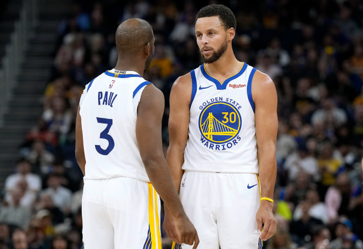 Stephen Curry and Chris Paul of the Golden State Warriors, just kinda standing and looking at each other in a preseason game.