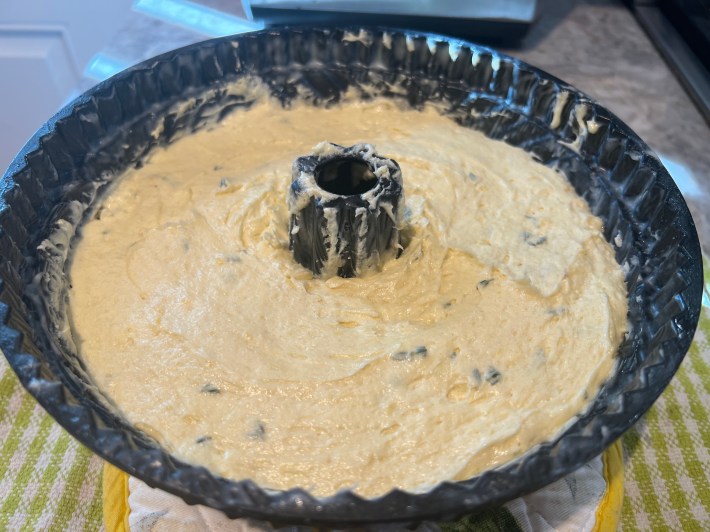 A pale batter spread into a greased bundt tin.