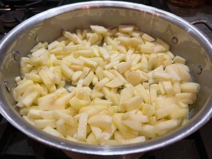 Chopped apples with butter and lemon juice in a sauté pan.