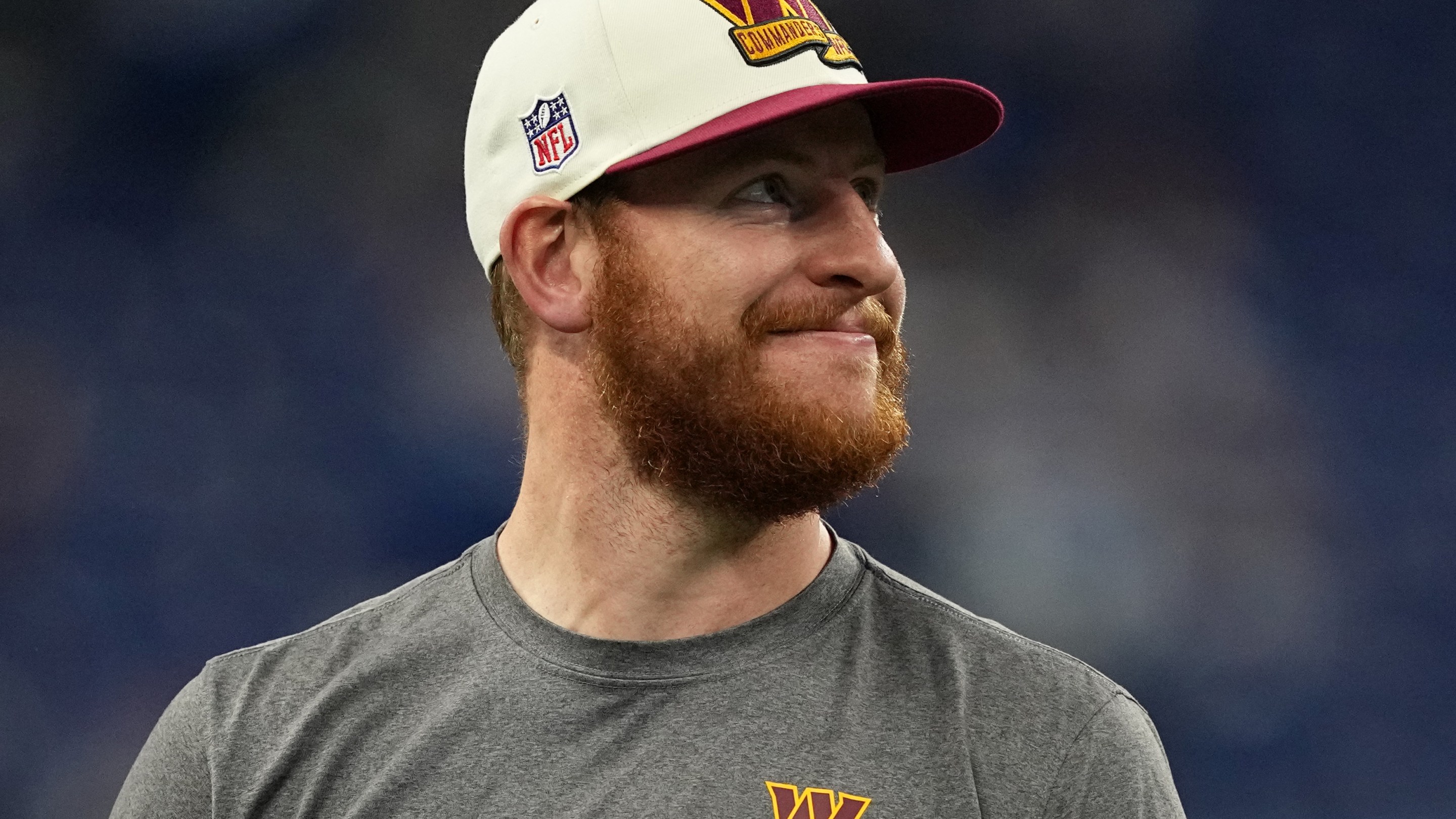 Carson Wentz grinning weirdly on the field before a Washington Commanders game in 2022.