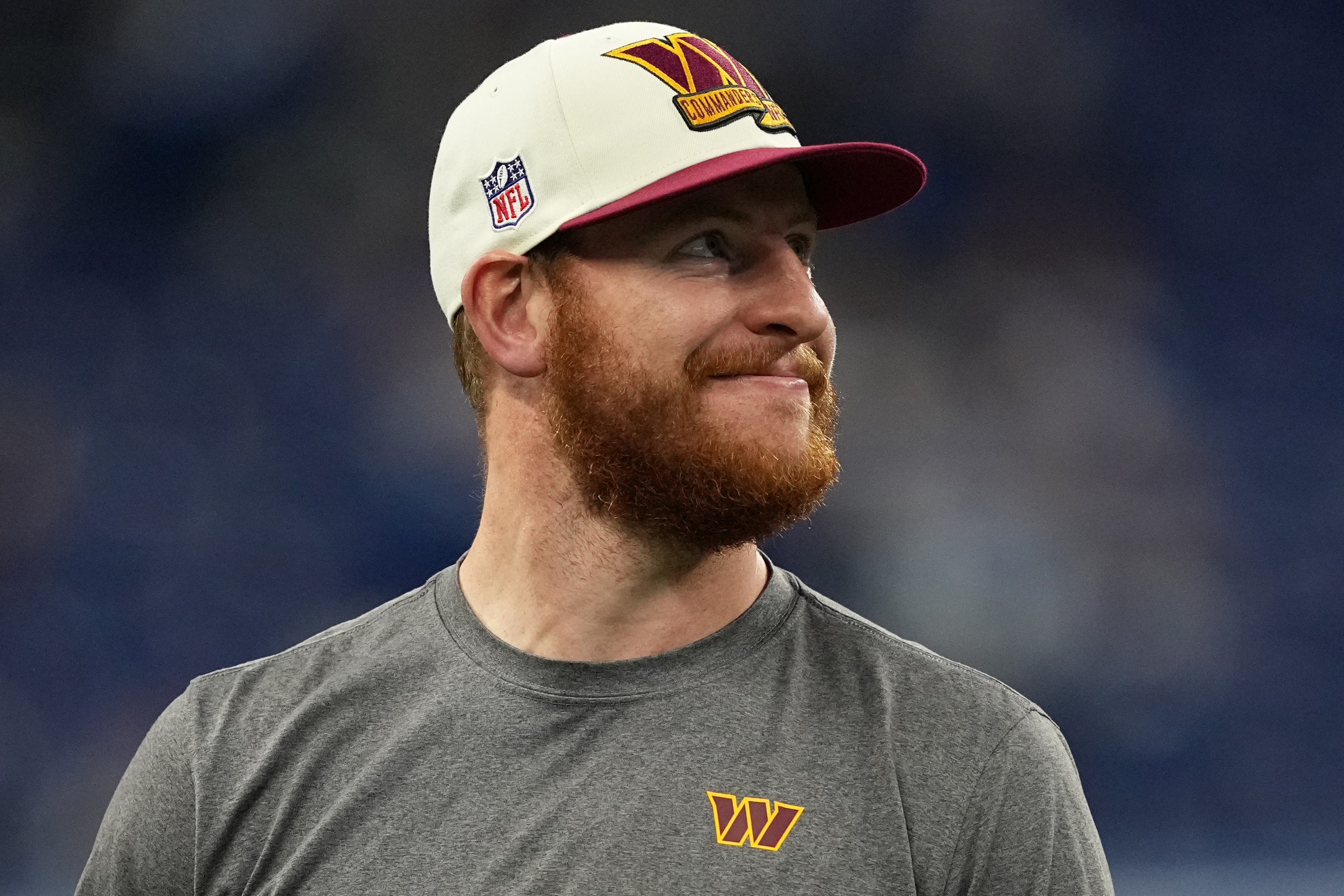 Carson Wentz grinning weirdly on the field before a Washington Commanders game in 2022.