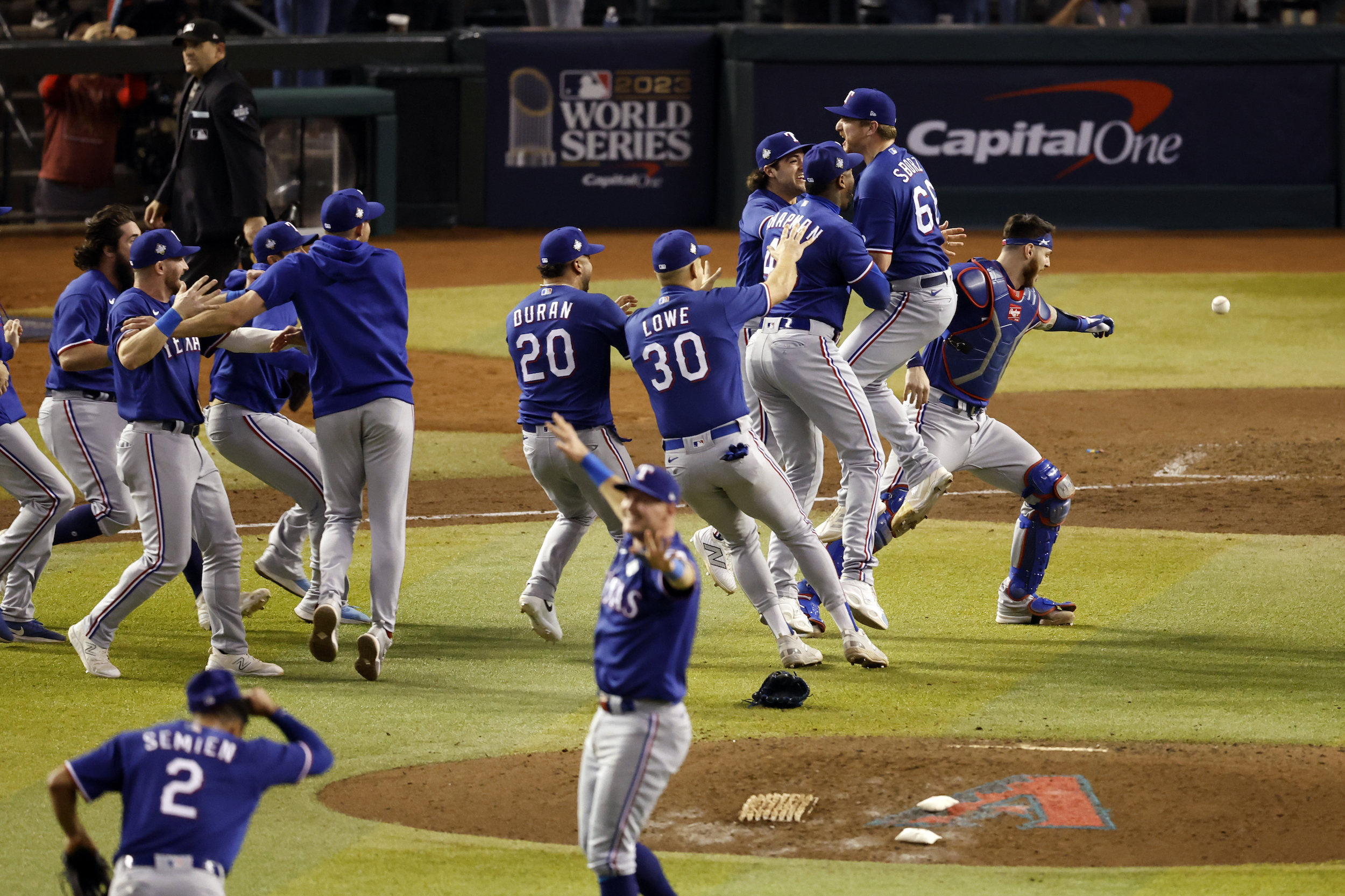 The Texas Rangers celebrate on the field after winning the World Series.