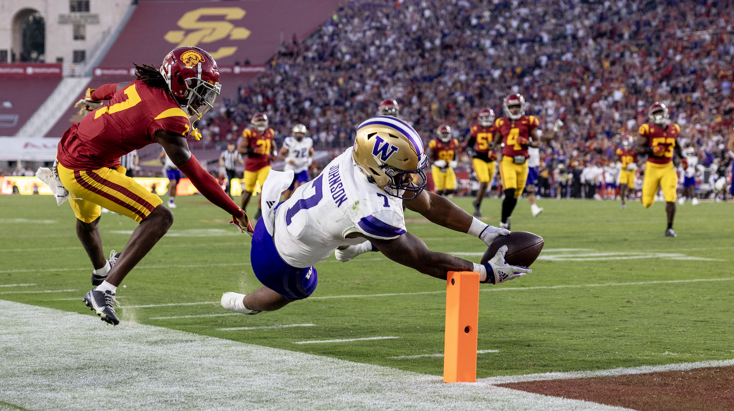 Washington Huskies running back Dillon Johnson (7) scores on a 52-yard-run against USC Trojans safety Calen Bullock (7) in the second quarter at the L.A. Memorial Coliseum November 4, 2023 in Los Angeles, California.