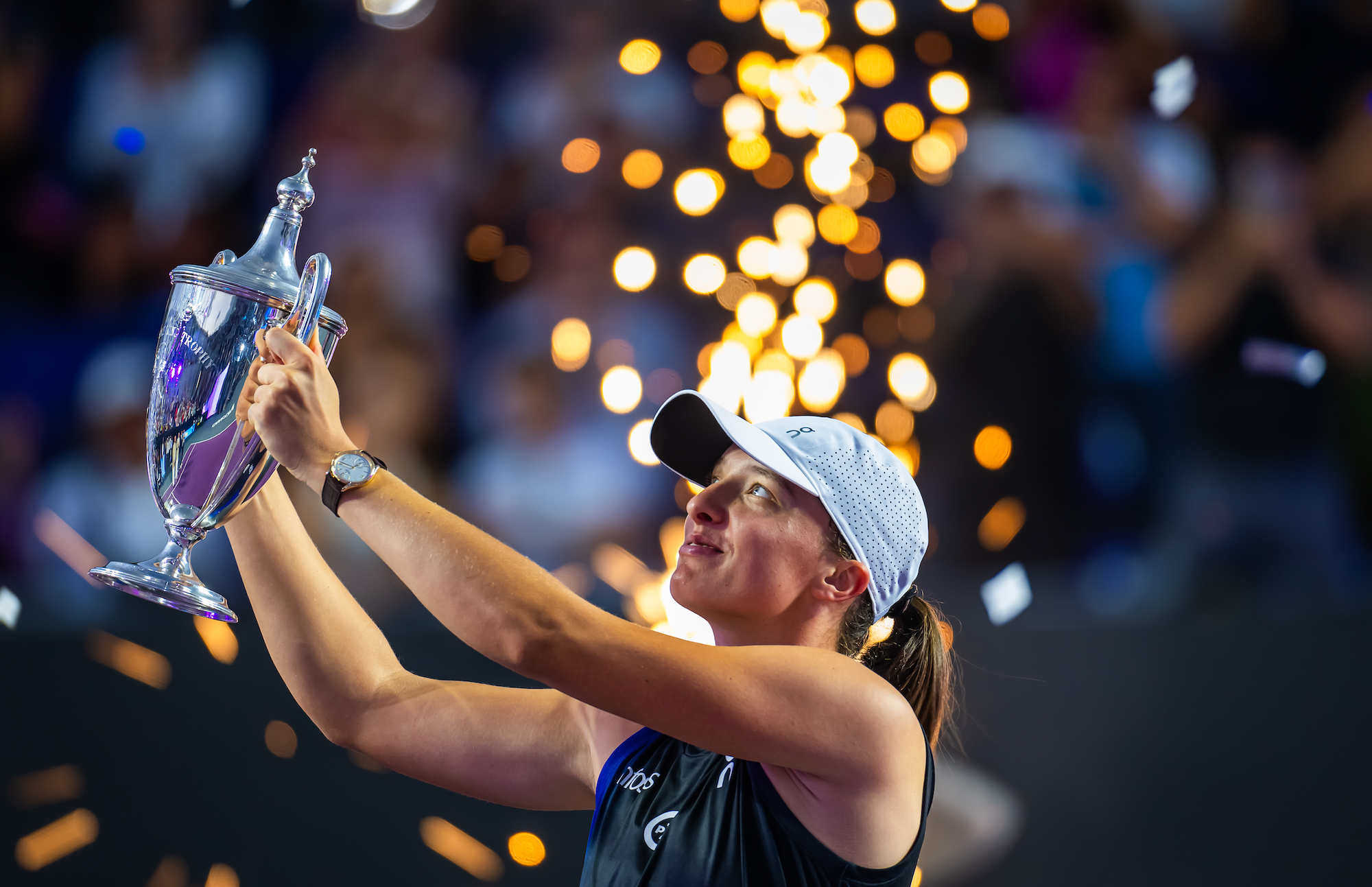 Iga Swiatek lifts the WTA Finals trophy in Cancun