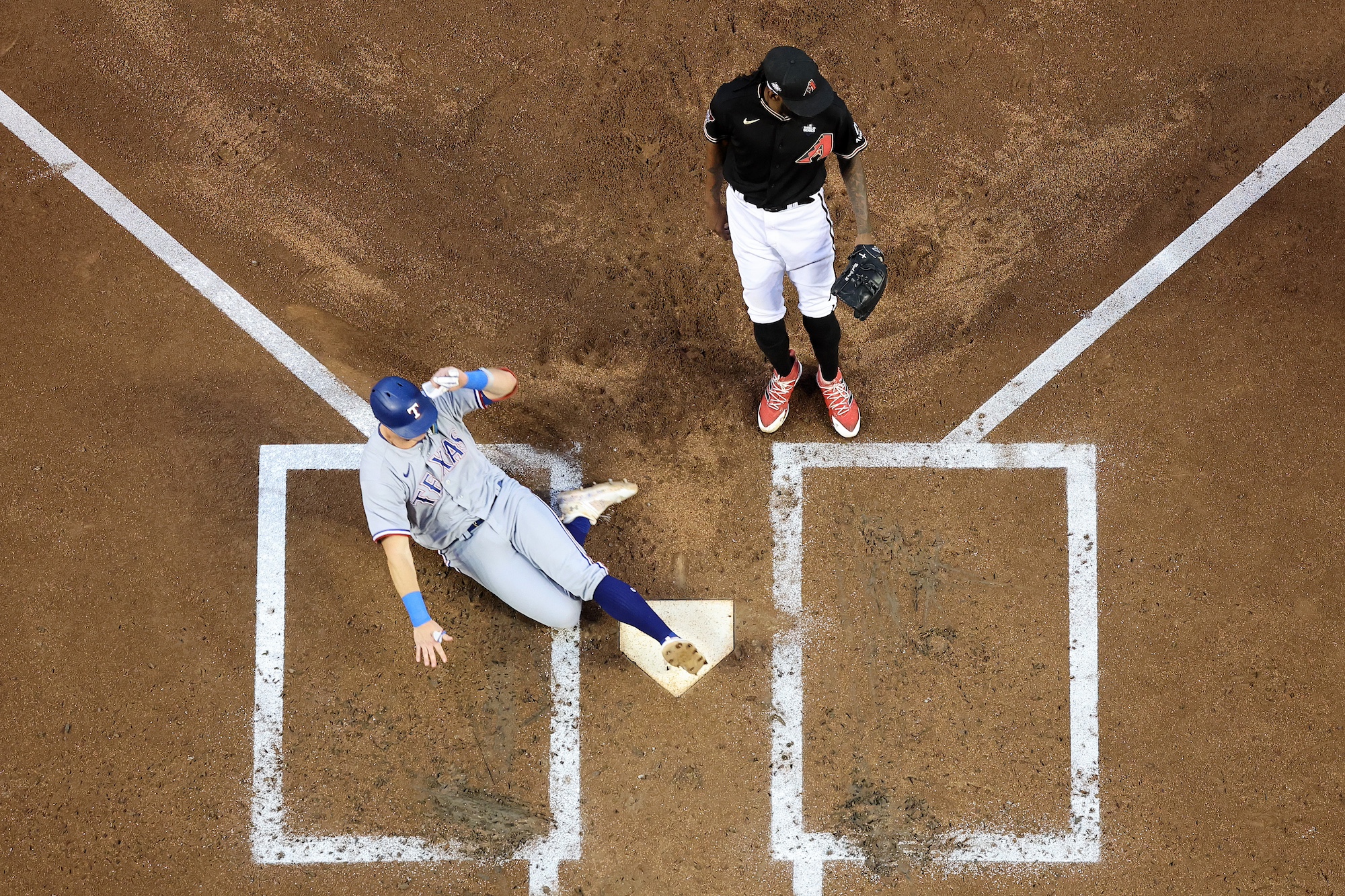 PHOENIX, ARIZONA - OCTOBER 31: Josh Jung #6 of the Texas Rangers slides into home plate to score a run on a wild pitch in the second inning against the Arizona Diamondbacks during Game Four of the World Series at Chase Field on October 31, 2023 in Phoenix, Arizona. (Photo by Christian Petersen/Getty Images)