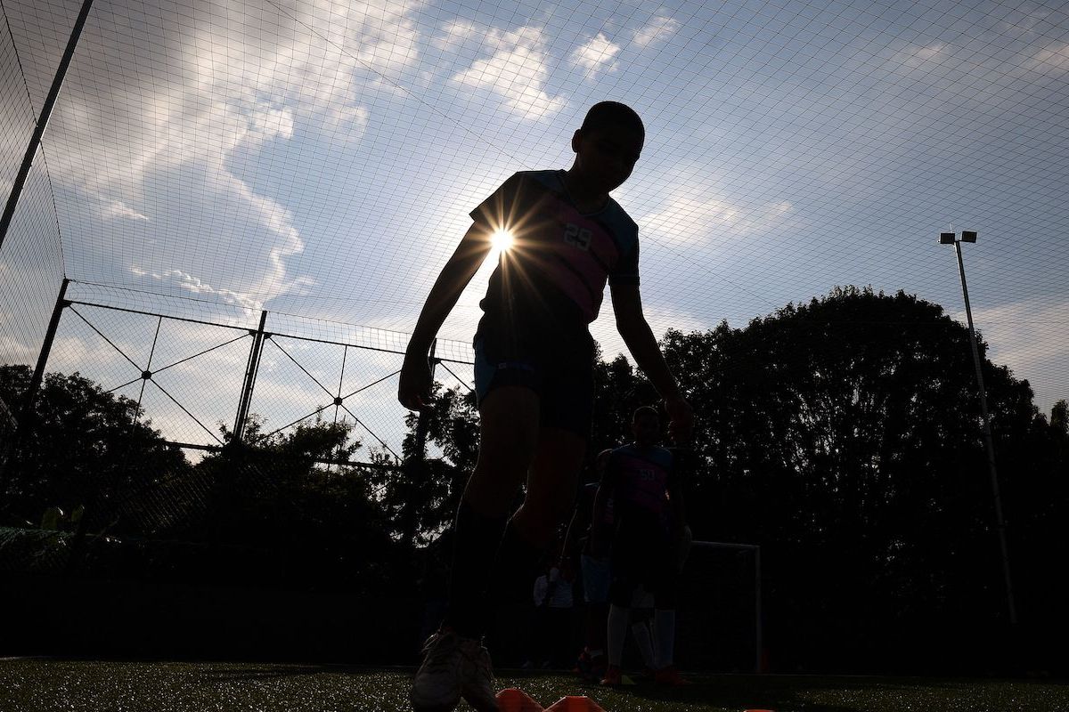 Silhouette of a child playing soccer