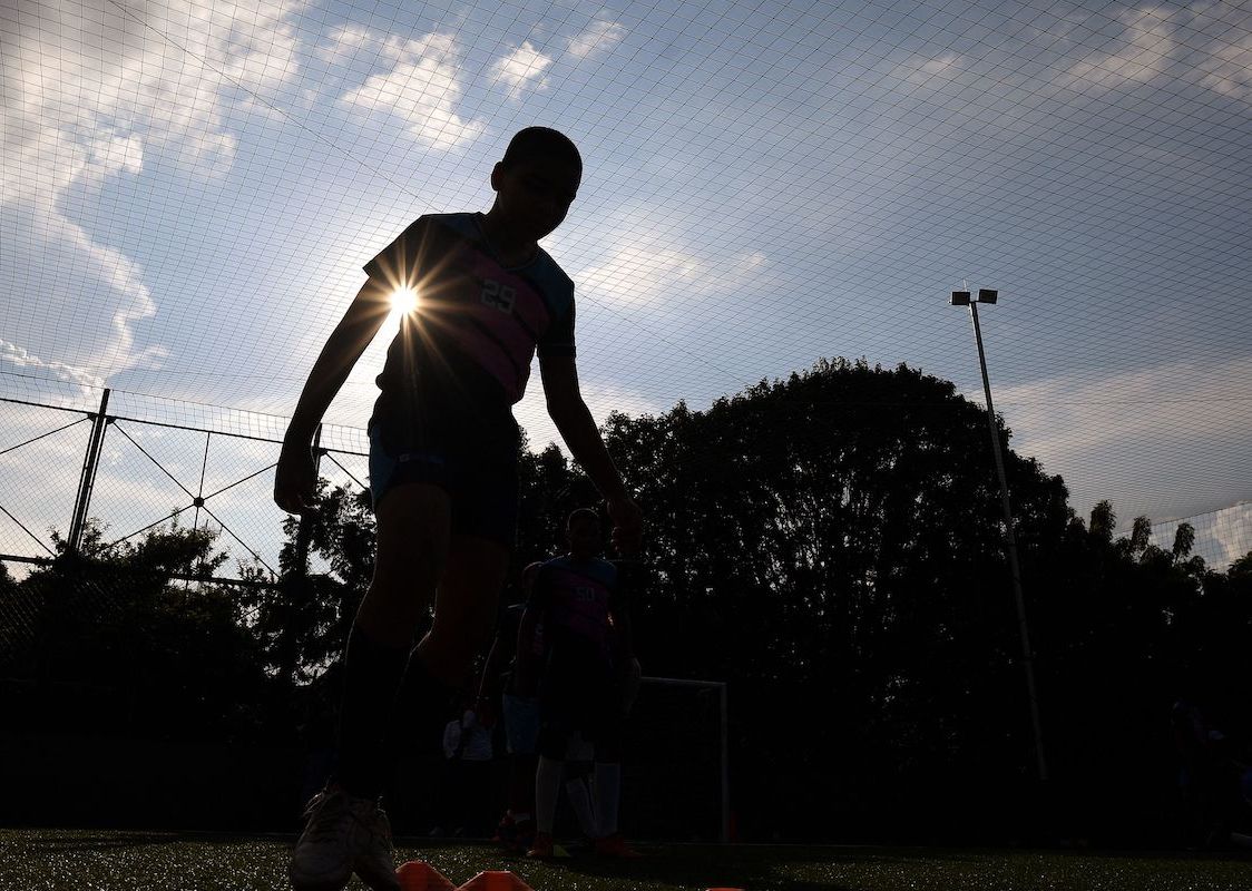 Silhouette of a child playing soccer