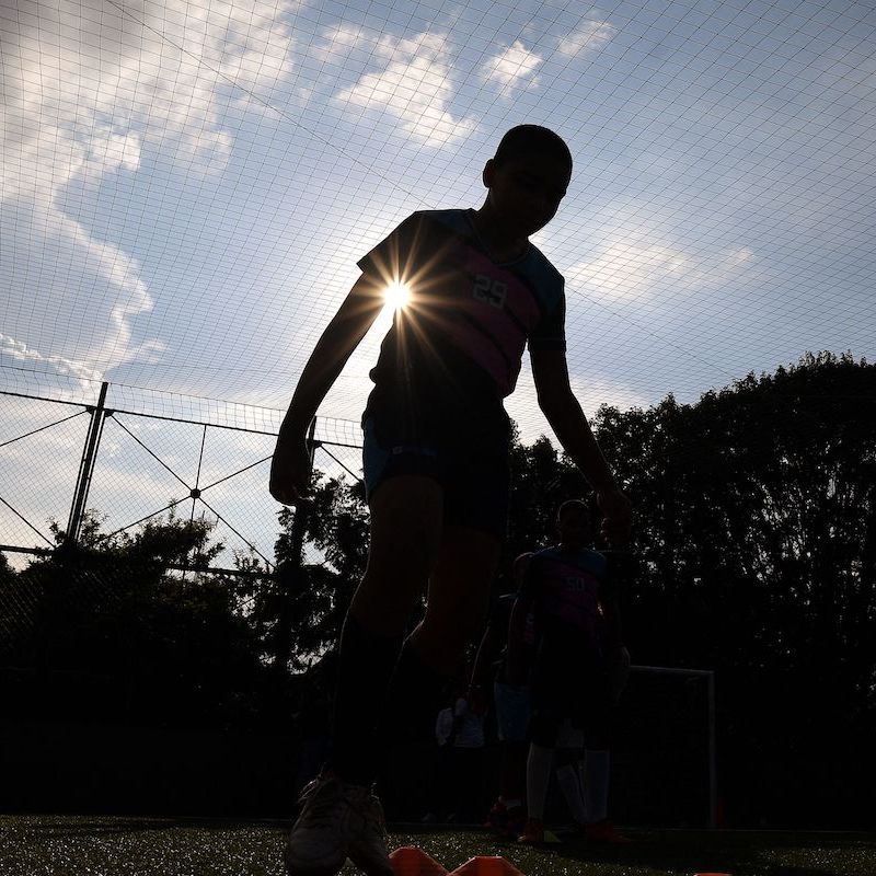 Silhouette of a child playing soccer
