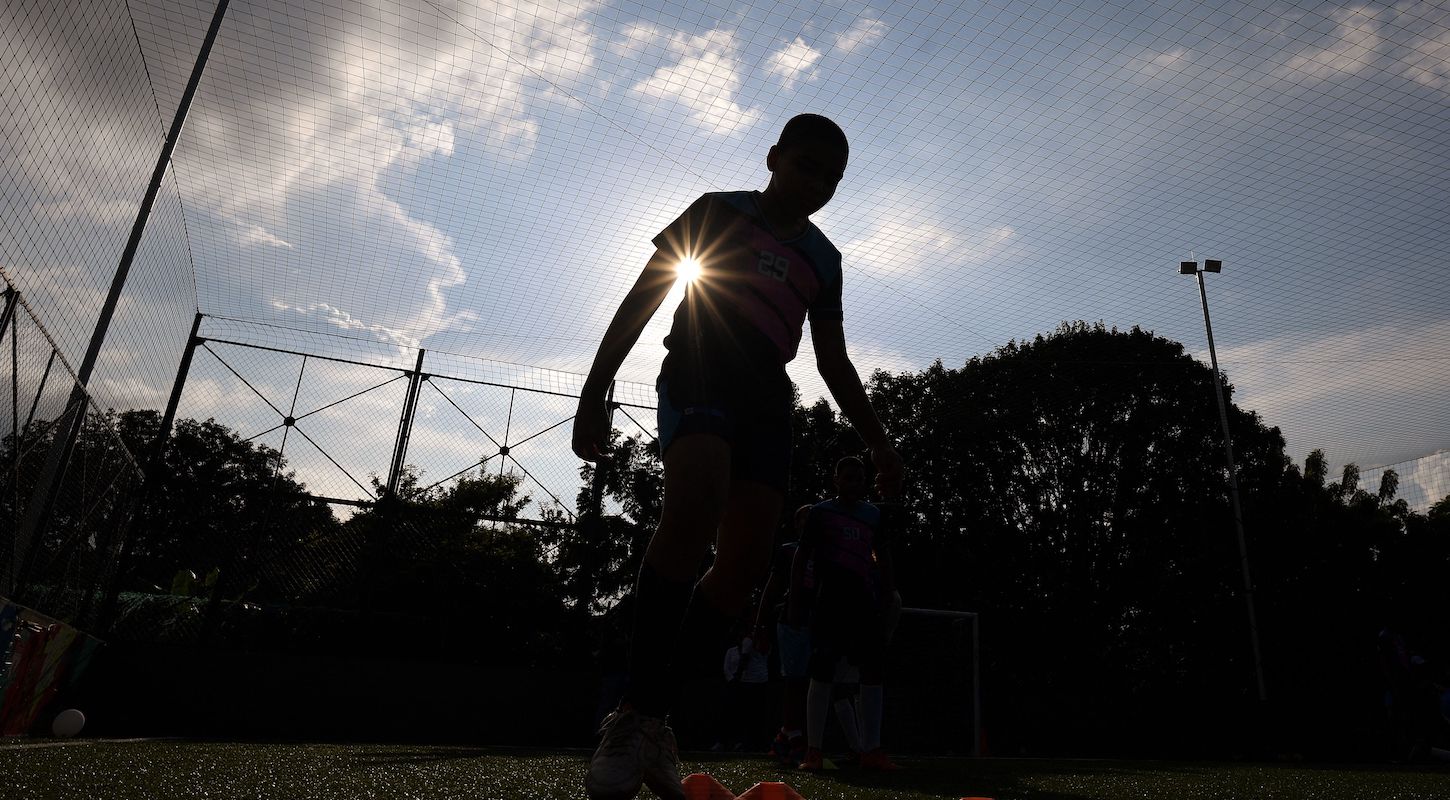 Silhouette of a child playing soccer