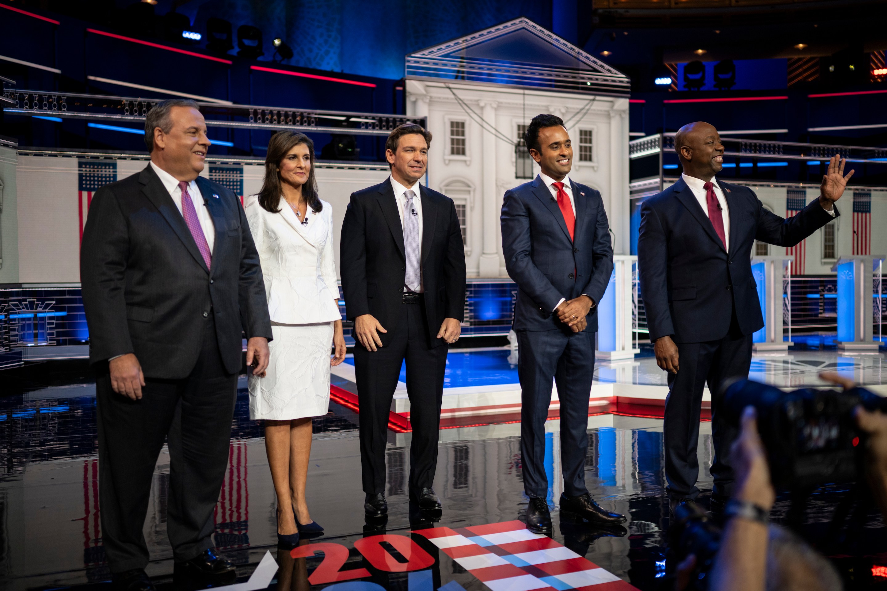 Chris Christie, Nikki Haley, Ron DeSantis, Vivek Ramaswamy, and Tim Scott standing onstage, all very normally, at a GOP primary debate in Miami.
