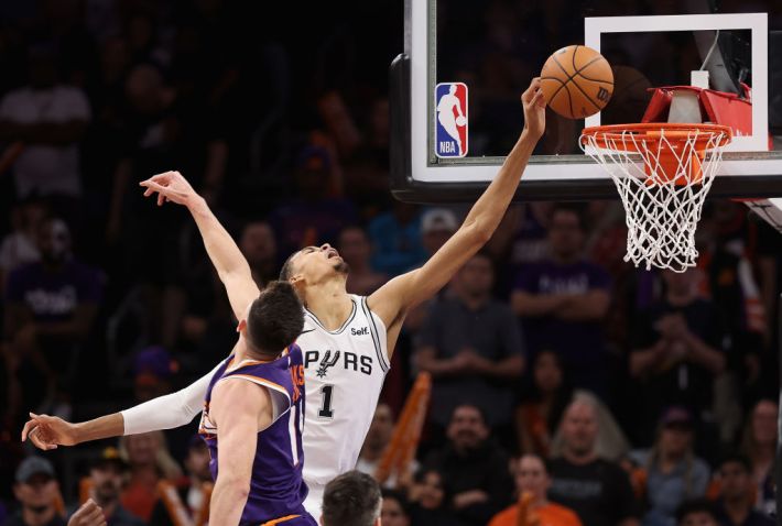 Victor Wembanyama dunks over a defender