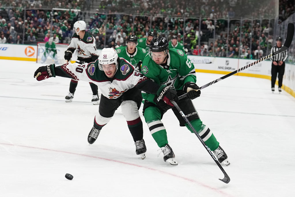 Sean Durzi tries to keep the puck away from Evgenii Dadonov