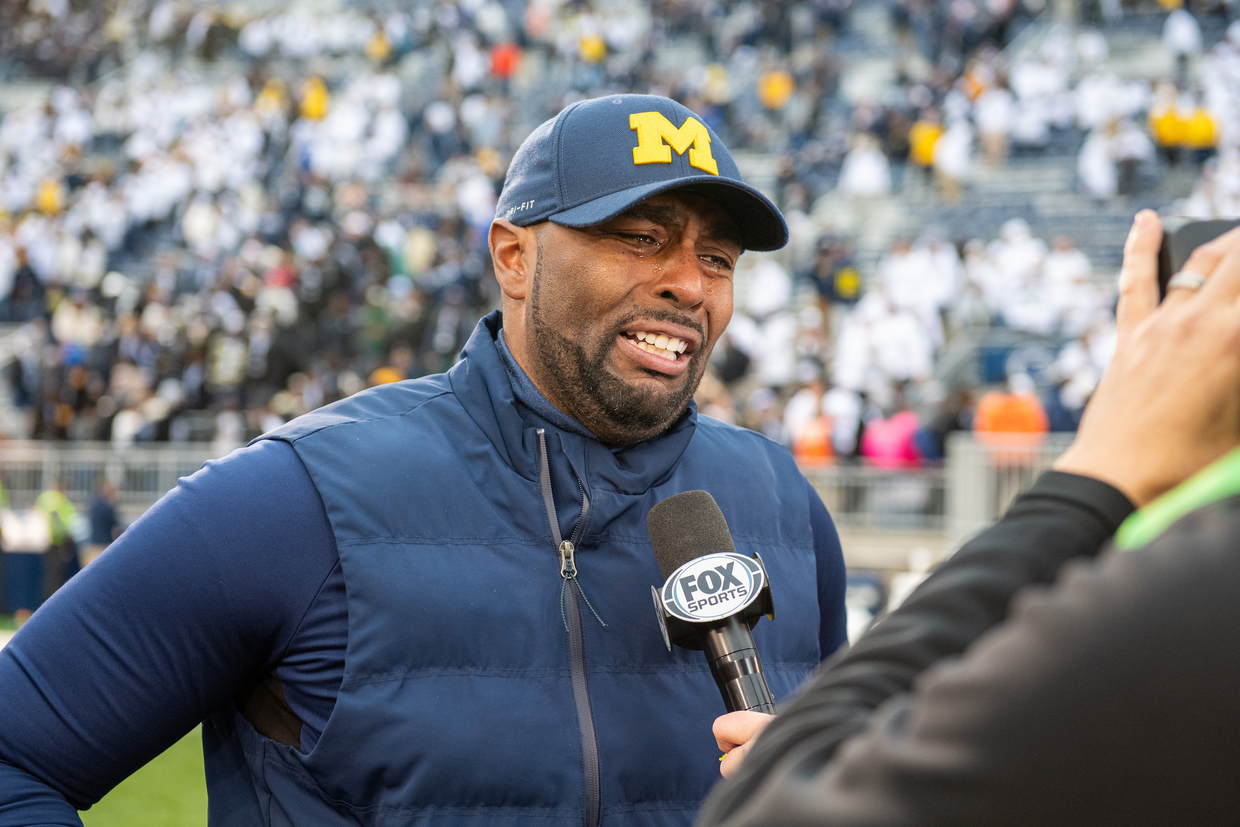 Sherrone Moore of Michigan weeps as if Jim Harbaugh died saving orphans from a fire, when in fact Harbaugh was suspended for cheating.