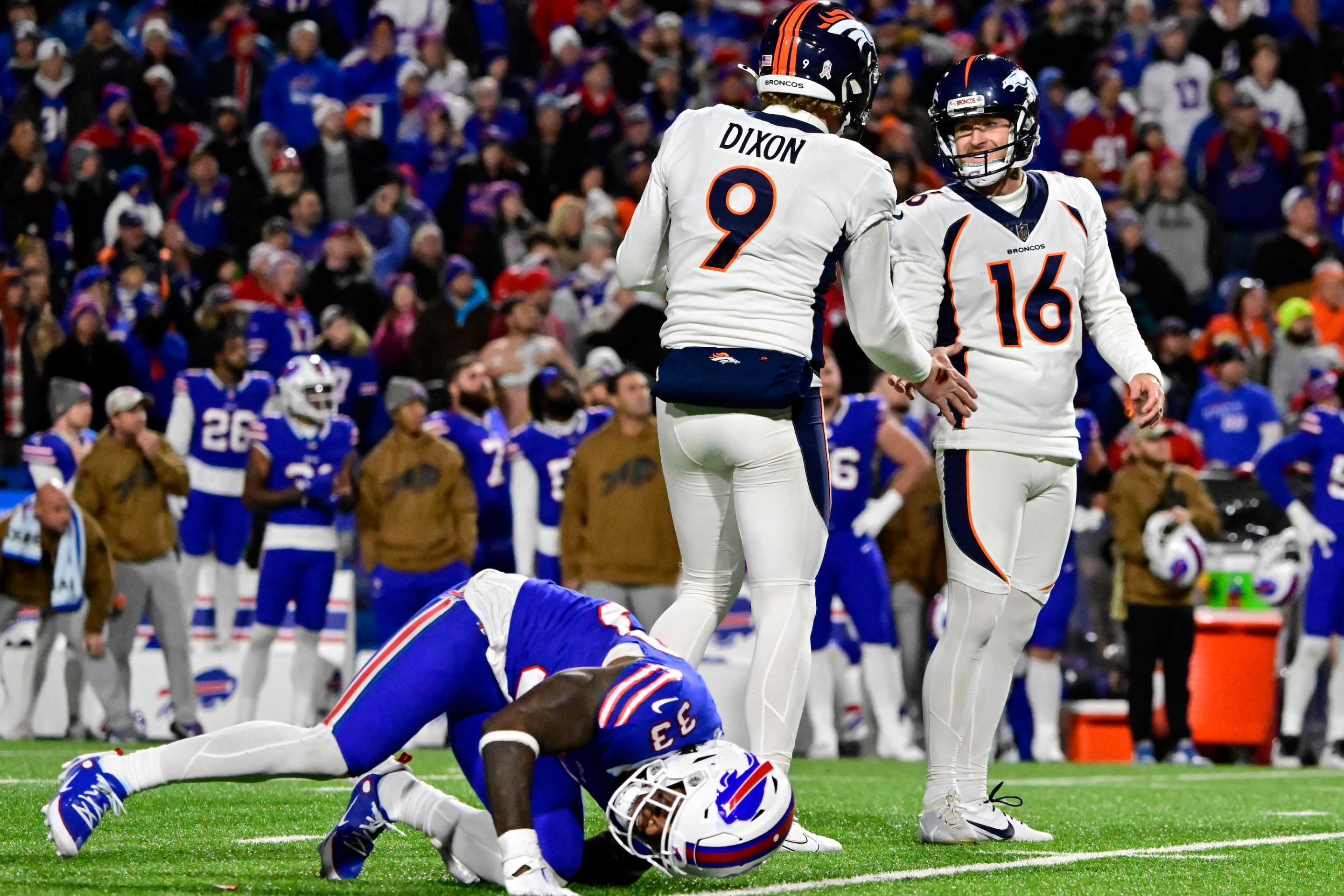 ORCHARD PARK, NY - NOVEMBER 13: Denver Broncos punter Riley Dixon (9) celebrates with place kicker Wil Lutz (16) who kicked the winning field goal against the Buffalo Bills in the fourth quarter at Highmark Stadium November 13, 2023. Buffalo Bills cornerback Siran Neal (33) moments after the kick, The Broncos won 24-22. (Photo by Andy Cross/The Denver Post)