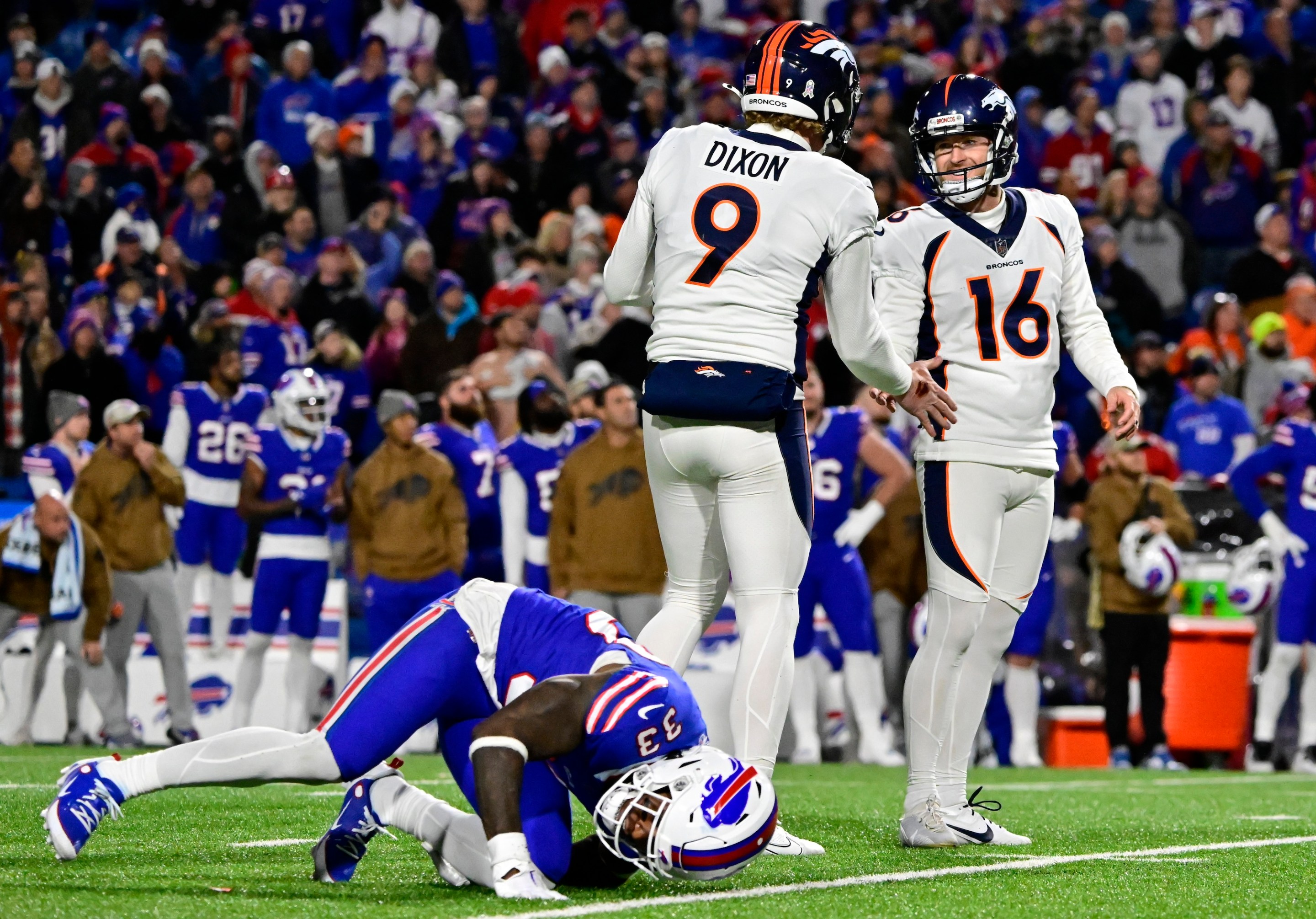 ORCHARD PARK, NY - NOVEMBER 13: Denver Broncos punter Riley Dixon (9) celebrates with place kicker Wil Lutz (16) who kicked the winning field goal against the Buffalo Bills in the fourth quarter at Highmark Stadium November 13, 2023. Buffalo Bills cornerback Siran Neal (33) moments after the kick, The Broncos won 24-22. (Photo by Andy Cross/The Denver Post)