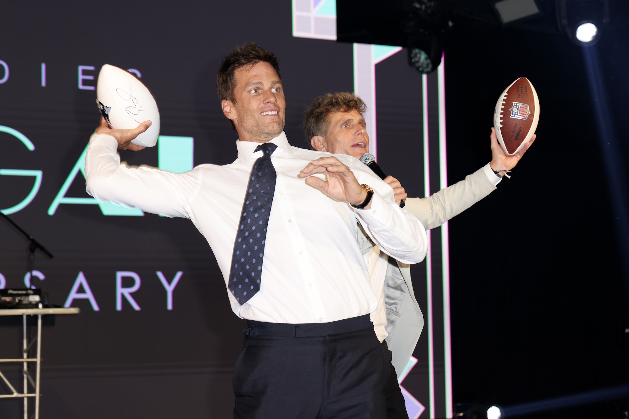 MIAMI, FLORIDA - NOVEMBER 17: Global Ambassador Tom Brady and Founder and CEO of Best Buddies International, Anthony K. Shriver are seen on stage at the 25th Annual Best Buddies Miami Gala at Ice Palace Film Studios on November 17, 2023 in Miami, Florida. (Photo by Alexander Tamargo/Getty Images for Best Buddies)