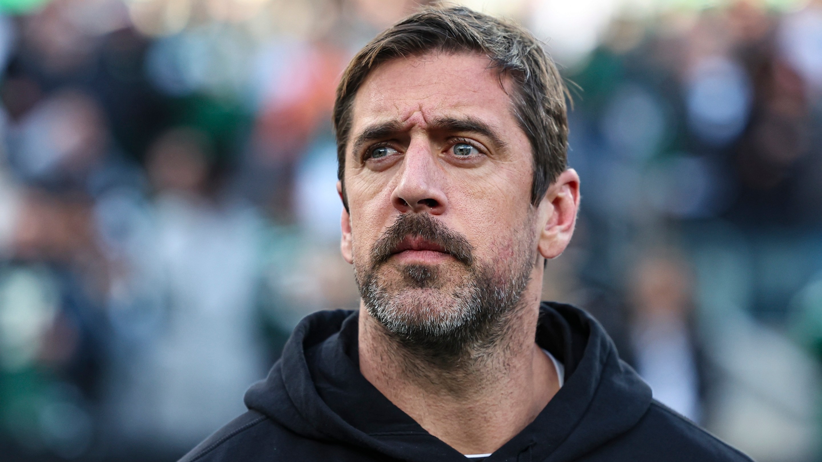 EAST RUTHERFORD, NJ - NOVEMBER 24: Aaron Rodgers #8 of the New York Jets looks on from the sideline during the national anthem prior to an NFL football game against the Miami Dolphins at MetLife Stadium on November 24, 2023 in East Rutherford, New Jersey. (Photo by Perry Knotts/Getty Images)