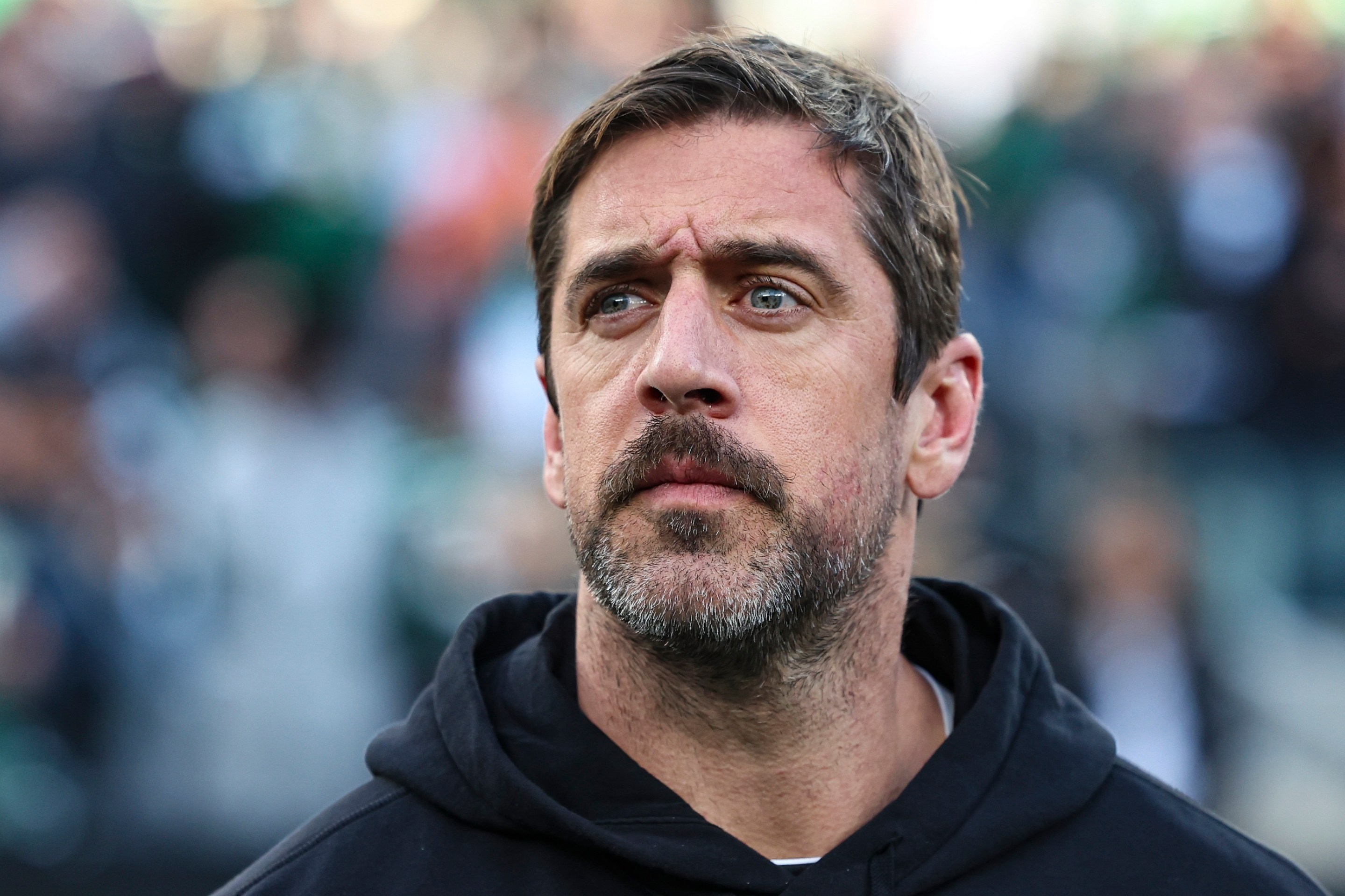EAST RUTHERFORD, NJ - NOVEMBER 24: Aaron Rodgers #8 of the New York Jets looks on from the sideline during the national anthem prior to an NFL football game against the Miami Dolphins at MetLife Stadium on November 24, 2023 in East Rutherford, New Jersey. (Photo by Perry Knotts/Getty Images)