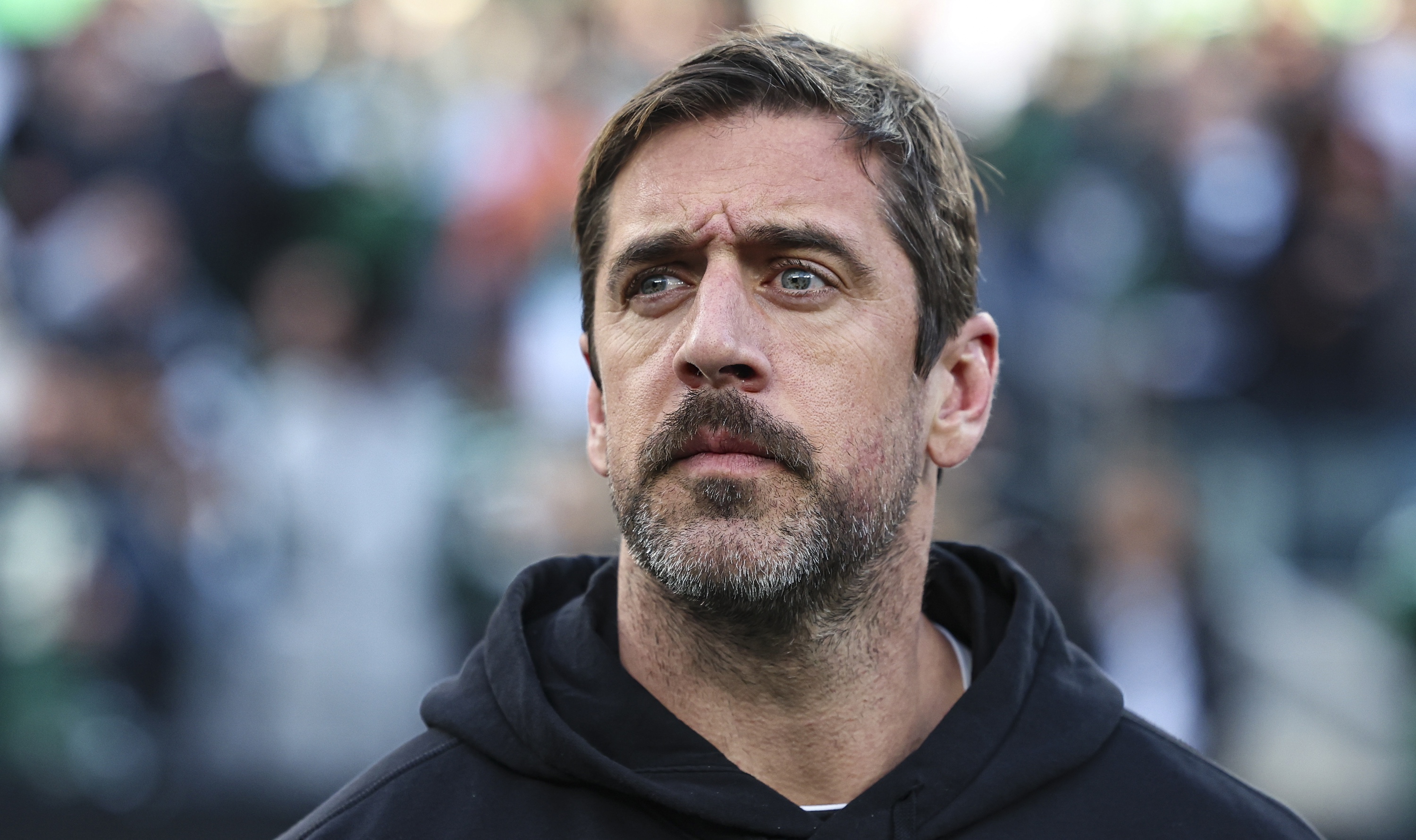 EAST RUTHERFORD, NJ - NOVEMBER 24: Aaron Rodgers #8 of the New York Jets looks on from the sideline during the national anthem prior to an NFL football game against the Miami Dolphins at MetLife Stadium on November 24, 2023 in East Rutherford, New Jersey. (Photo by Perry Knotts/Getty Images)