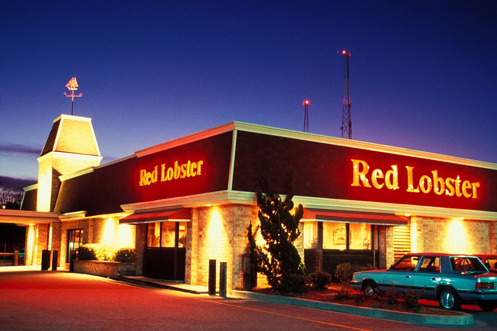 The exterior of a Red Lobster restaurant illuminated by its neon sign at dusk in South Carolina.