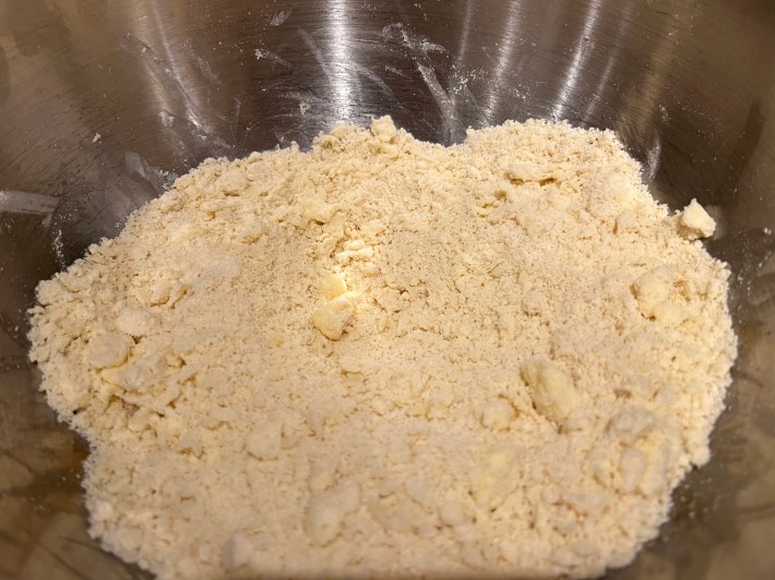 A bowl of flour with butter roughly mixed in.