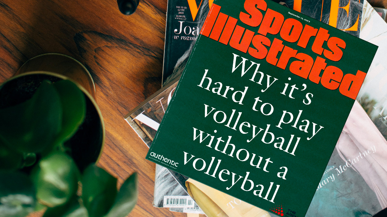 A coffee table with some Vogue magazines on it, and a Sports Illustrated on top. It's the famous "Why the University of Miami should drop football" cover but it's been edited to say "Why it's hard to play volleyball without a volleyball."